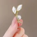 Elegant leaf-shaped brooch with white shell leaves and a radiant round pearl accent. - Mother Of Pearl Effect Flower Leaf Shaped / Pearl Leaf