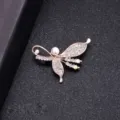 Elegant rose gold butterfly brooch with pearl and sparkling rhinestones on black background. - Daffodil Style