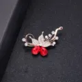 Elegant gold-tone floral brooch with clear rhinestones and pear-shaped red crystals - Rose Style