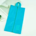 Detail view of blue travel shoe bag, waterproof fabric with center zipper and top handle. - Sky Blue