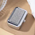 Macro view of portable silver metal cigarette case with sparkling rhinestone lid details - White