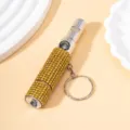 Nahaufnahme eines 3-in-1 Pfeife Kompass Taschenlampe Schlüsselanhängers mit goldenen Strass. - 3-in-1 Funktion (Pfeife + Kompass + Taschenlampe) / Gelb