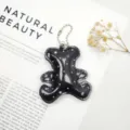 Detailed shot of a bear shaped leather keychain with shiny rhinestone accents - Black