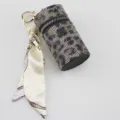 Detailed view of a luxury leopard rhinestone lipstick case keychain with silk scarf - Gold Leopard