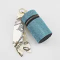 Detailed shot of a blue rhinestone lipstick holder with a chain-print silk scarf - Lake Blue