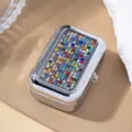 Close-up detail of a portable silver metal box decorated with vibrant multicolored rhinestones - Colorful Zirconia