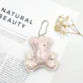Close-up of a sparkling pink leather bear keychain with rhinestone accents - Pink