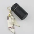 Luxury black rhinestone lipstick case keychain with an elegant patterned silk ribbon scarf detail - Black