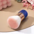 Vista macro del pennello per unghie di lusso con strass blu e setole sfumate rosa - Blu zaffiro