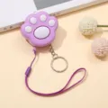 Primer plano de una alarma con forma de pata de gato lila con cordón y llavero a juego - Púrpura