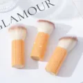 Macro view of three professional orange rhinestone-covered mushroom head makeup brushes. - Three-Piece Set / AB Orange