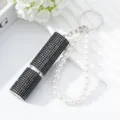 Close-up of luxury 5ml rhinestone perfume atomizer keychain with pearl wrist strap - Black