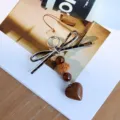 Detailed macro view of vintage leopard print leather bow bag charm with heart pendant - Heart (Leopard)