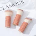 Close-up of three sparkling rhinestone-handled mushroom head makeup brushes on white background - Three-Piece Set / AB Red