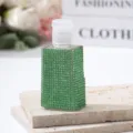 Detail showing sparkling green rhinestone decoration on travel perfume dispensing bottle - 30ml / Green