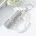 Close-up of luxury 5ml rhinestone perfume atomizer with elegant pearl keychain strap - AB White