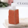 Close-up of a luxury travel perfume bottle covered in sparkling orange rhinestones - 30ml / Orange Red
