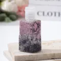 Close-up of a pink gradient rhinestone-covered travel spray bottle on a stone base - 30ml / Pink Grey Gradient