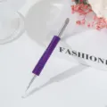 Close-up detail of a professional stainless steel nail pusher with a purple rhinestone handle - Deep purple