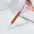 Close-up detail of stainless steel nail art tool featuring an orange rhinestone handle - Orange Red