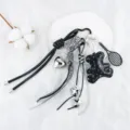 Dettaglio di un ciondolo per borsa stile Y2K con pendenti a forma di orso, cuore e racchetta. - Stile Racchetta da Tennis / Nero