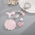 Détail du pendentif coquillage et queue de sirène en acrylique rose pailleté pour sacs. - Rose