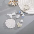 Vue détaillée d'un porte-clés en acrylique sur le thème de l'océan avec coquillage - Blanc