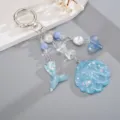 Vue détaillée du porte-clés thème océan avec coquillage bleu et queue de sirène. - Bleu
