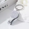 Macro close-up of a silver rhinestone-studded nail clipper keychain and bottle opener - AB White