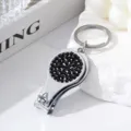 Close-up of a silver multifuntional nail clipper keychain with black rhinestone inlay - Black
