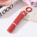 Detalle de un frasco atomizador de perfume rojo de 5ml con un lazo y un llavero. - Rojo