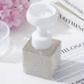 Close-up of elegant flower-shaped pump head on rhinestone-encrusted foaming bottle - White