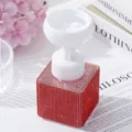 Detailed macro shot of red rhinestone covered base and white flower shaped foam pump head - Red