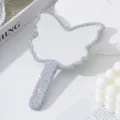 Primo piano di uno specchio a mano a forma di farfalla decorato con strass lucenti. - Zircone AB