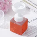 Detail shot of elegant orange rhinestone soap dispenser with white flower-shaped pump - Orange Red