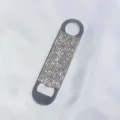Detailed view of a sparkling silver rhinestone-encrusted portable metal beer bottle opener - White