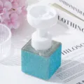 Close-up of blue rhinestone foam dispenser bottle with flower-shaped pump head. - Lake Blue