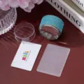 Detail showing a blue rhinestone nail stamper, white scraper, and lace design plate - Lake Blue