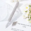 Detailed macro view of a silver rhinestone nail art pen with five interchangeable metal tips - AB White