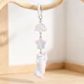 Close-up of cute white flocked cat keychain with iridescent star and bell charms - Spring Buckle (Style 2)