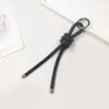 Close-up of black rhinestone-encrusted rope charm with silver ring and end caps - Black