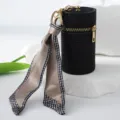 Detailed view of black rhinestone lipstick pouch with houndstooth silk scarf charm - Black