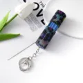 Primer plano de un atomizador de perfume con diamantes de imitación y llavero plateado. - Mezcla Azul Negra (C6)