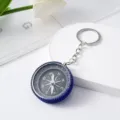 Detailed view of a mini outdoor compass keychain with blue rhinestone-encrusted rim - Sapphire Blue