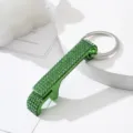 Close-up view of a green rhinestone studded aluminum alloy bottle opener keychain charm - Green