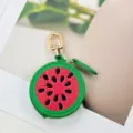 Detailed close-up of a cute watermelon-shaped PU leather coin purse with a premium golden clasp. - Watermelon Style