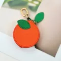 Close-up detail of cute orange-shaped PU leather coin purse with gold metal clasp - Orange Style