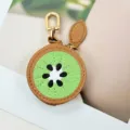 Close-up of a cute kiwi fruit shaped PU leather mini pouch with gold zipper and hook. - Kiwi