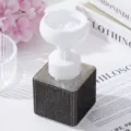 Detailed view of white flower-shaped foam pump on a black rhinestone soap dispenser - Black