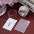 Detailed macro view of rhinestone-decorated nail art stamper with scraper and pattern plate - White